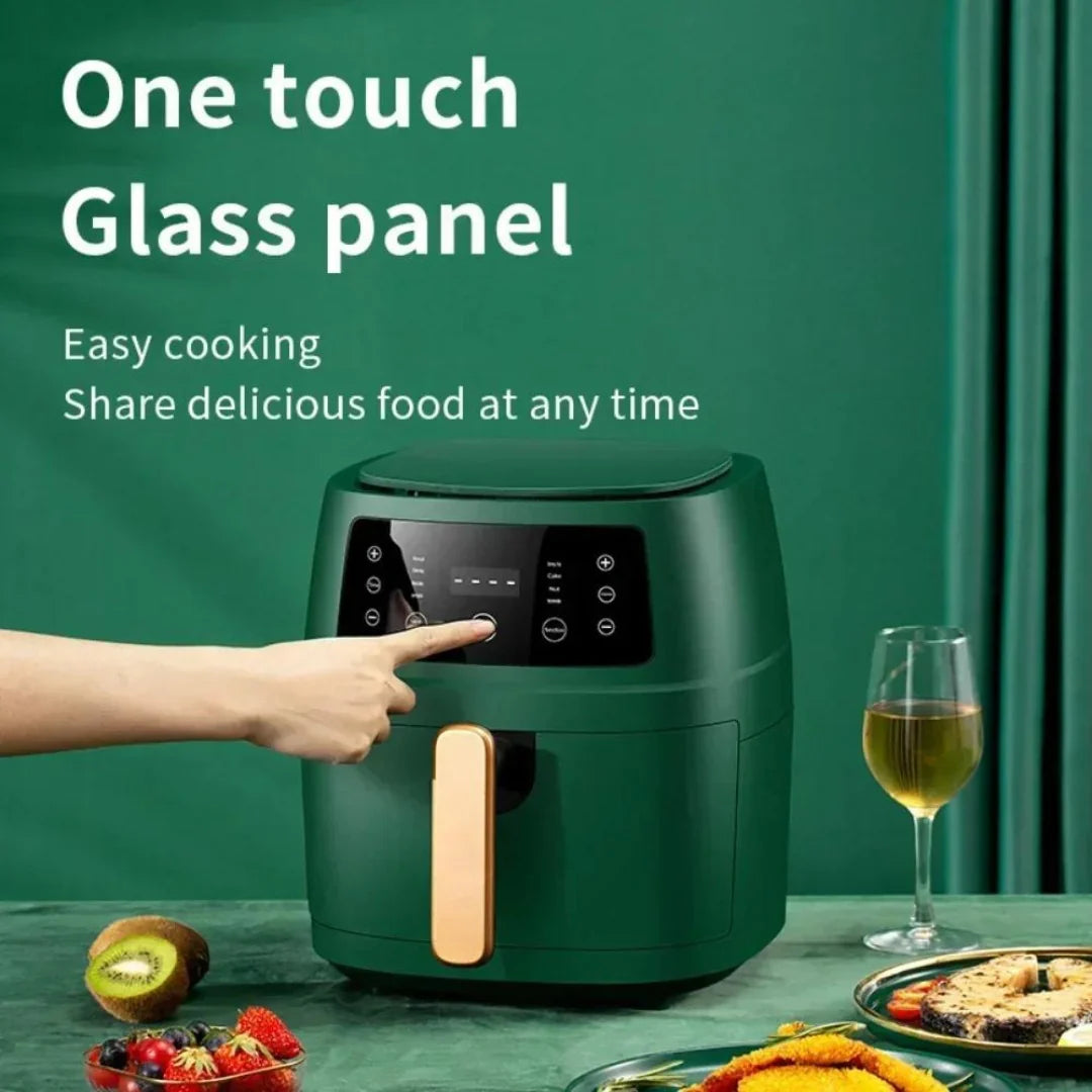 Green electric air fryer with glass panel on a green table with food and a glass of wine.