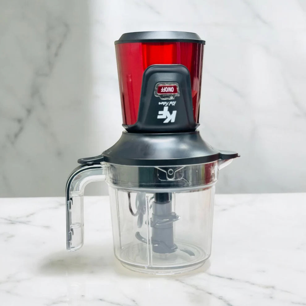 Kitchen appliance with red top and clear base on a white marble surface