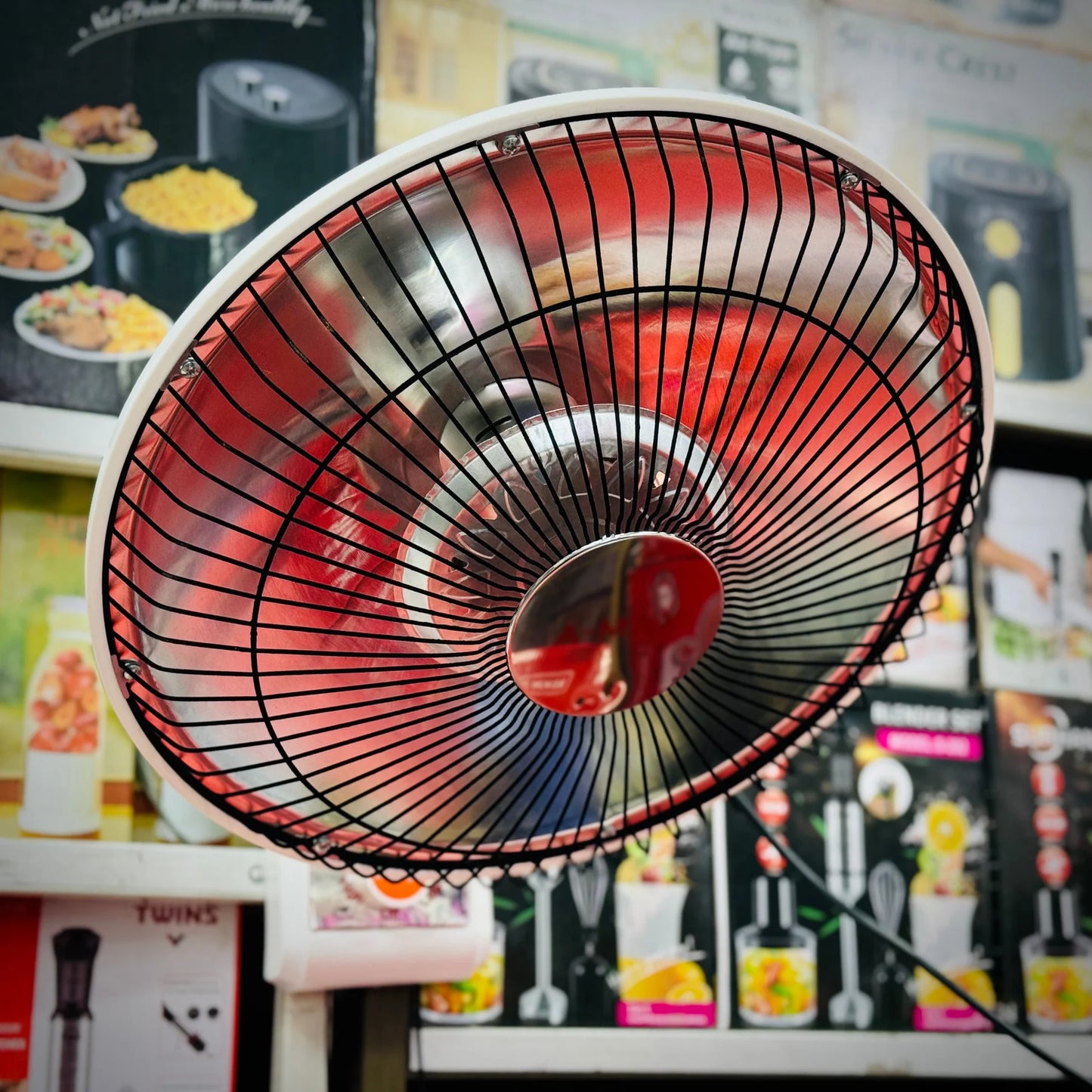 Close-up of a red electric fan with a blurred background