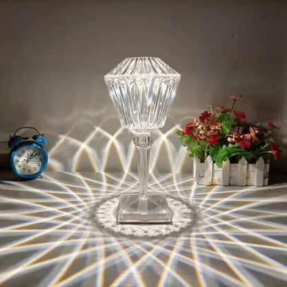 Crystal lamp casting geometric shadows on a floor with a clock and flowers in the background.