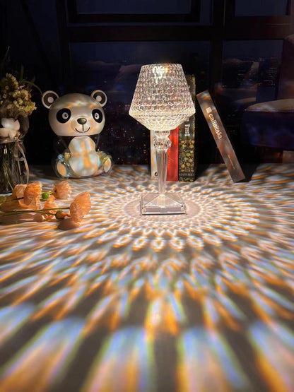 Decorative lamp casting colorful patterns on a surface with a panda figurine and other items in the background.