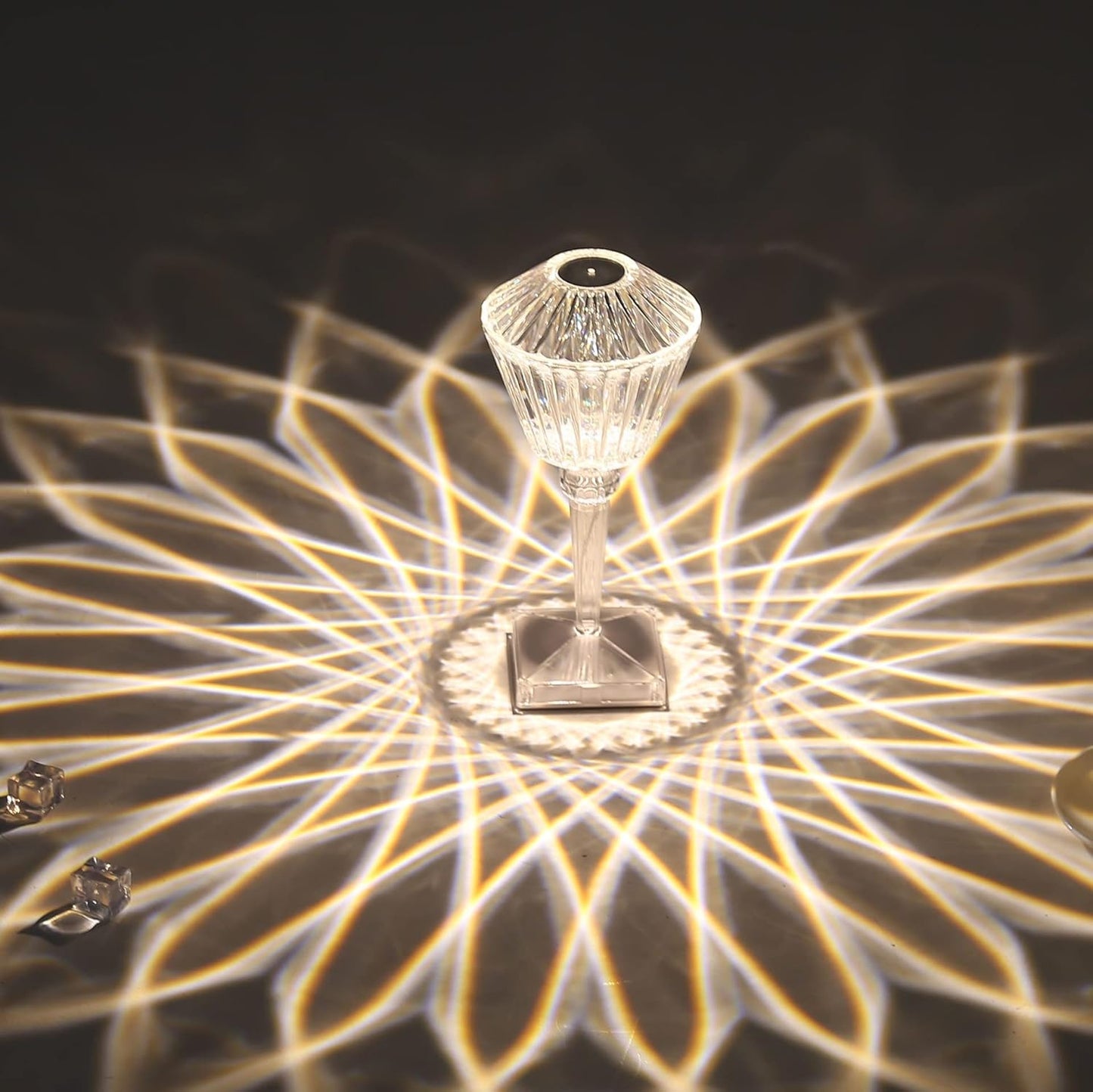 Decorative lamp with crystal design casting a pattern on a dark surface