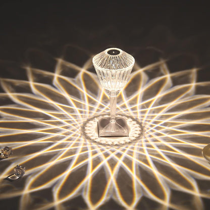 Decorative lamp with crystal design casting a pattern on a dark surface