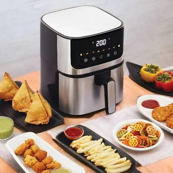 Philips air fryer with various fried foods on a table