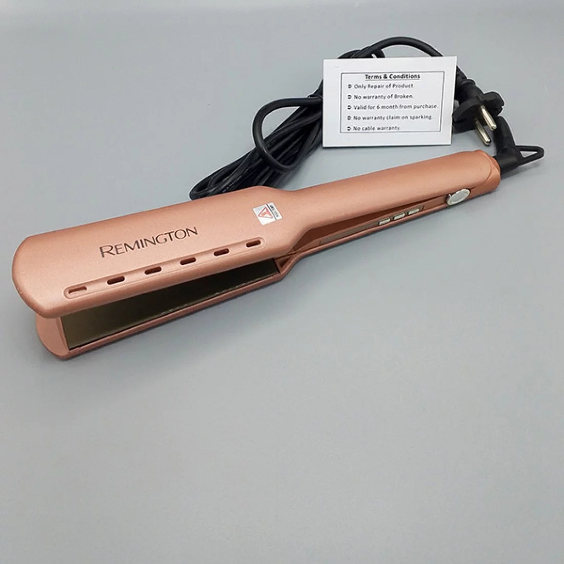 Rose gold Remington hair straightener on a gray background