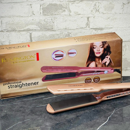 Rose gold hair straightener with packaging on a gray surface and brick wall background