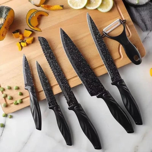 Set of black kitchen knives on a cutting board with vegetables