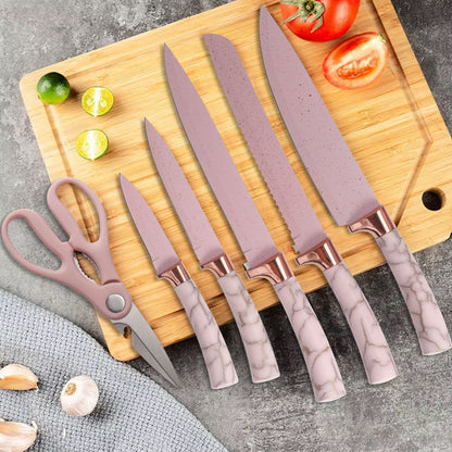 Set of knives with pink handles on a wooden cutting board